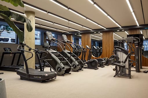 Fitness center with cardio equipment and wood paneling at 260 Gold Apartments, Brooklyn, New York
