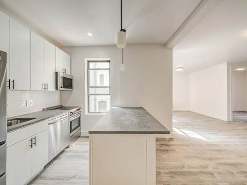 A kitchen with white cabinets and a granite countertop.