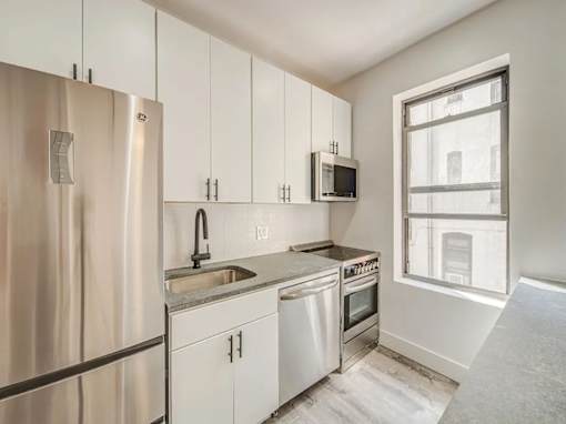 A kitchen with white cabinets and stainless steel appliances.