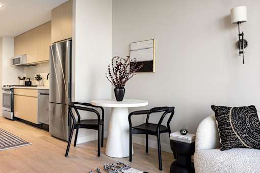 a living room with a small table and a kitchen at The Paxton, Brooklyn, 11201