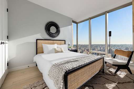 a bedroom with a bed and a view of the city at The Paxton, Brooklyn, 11201