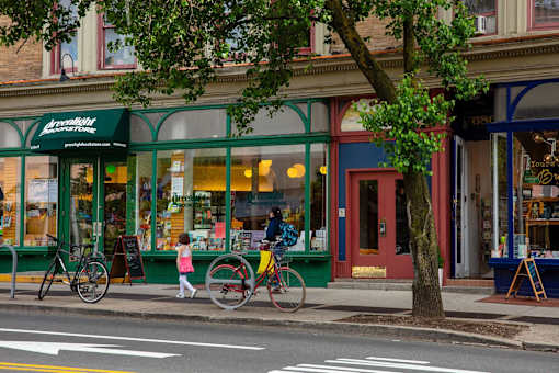 a man walking down the street with a bike at The Paxton, Brooklyn, New York