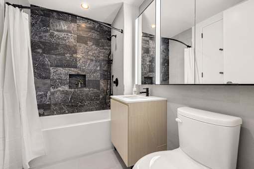 a bathroom with a toilet and a shower and a sink at The Paxton, Brooklyn