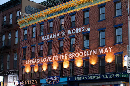 a building with a sign that reads spread love its the way at The Paxton, Brooklyn, NY