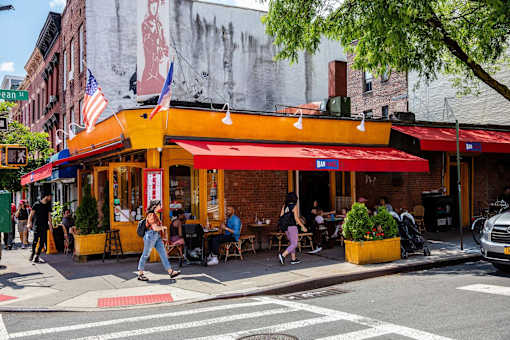 people walking down the street in front of a restaurant at The Paxton, Brooklyn, NY 11201