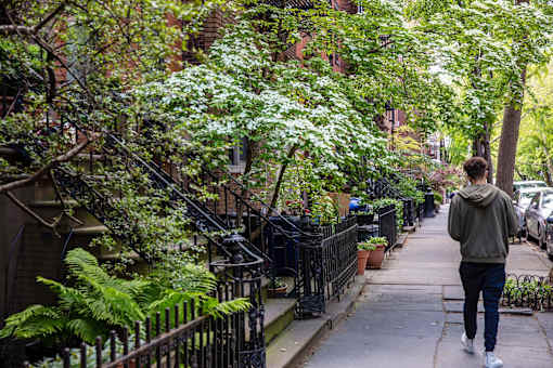 a man is walking down a sidewalk at The Paxton, Brooklyn, NY