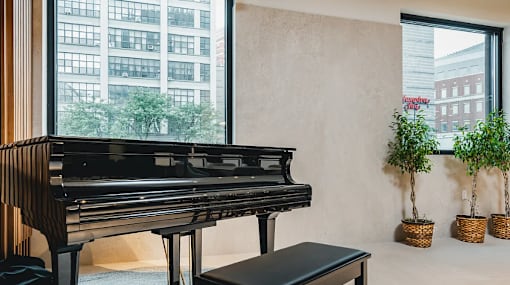 Grand piano near window with indoor plants at 260 Gold Apartments, New York, 11201