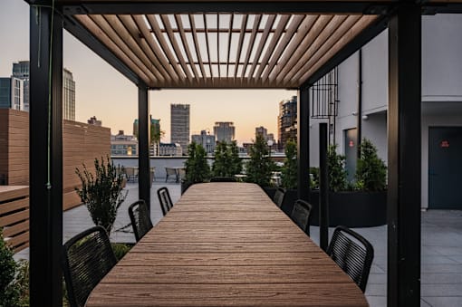 Rooftop dining deck with slatted pergola and city views at 260 Gold Apartments, Brooklyn, NY