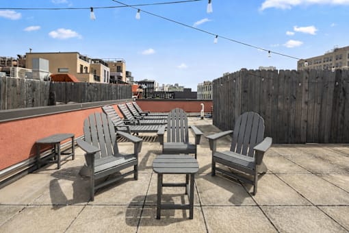 A patio with grey furniture and a wooden fence.