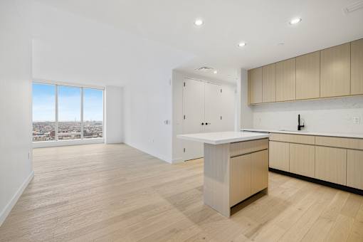 a living room with a kitchen and a window at The Paxton, Brooklyn, New York