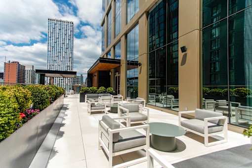 A patio with white furniture and a building in the background.