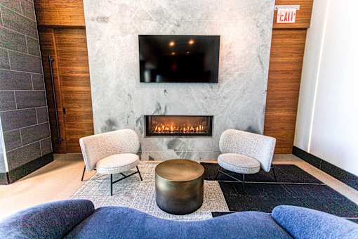 A living room with a fireplace and a flat screen TV mounted on the wall.