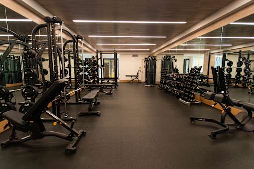 A spacious gym with a variety of equipment including treadmills, weights, and exercise machines.