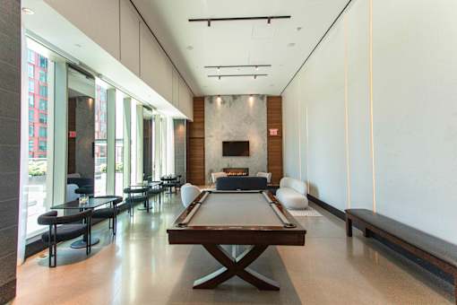 A billiard table is in the middle of a room with a fireplace.