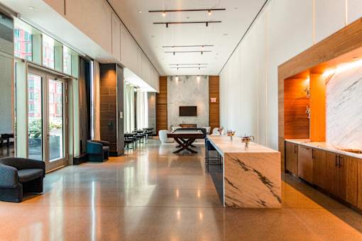 A modern kitchen with a marble countertop and a long table.