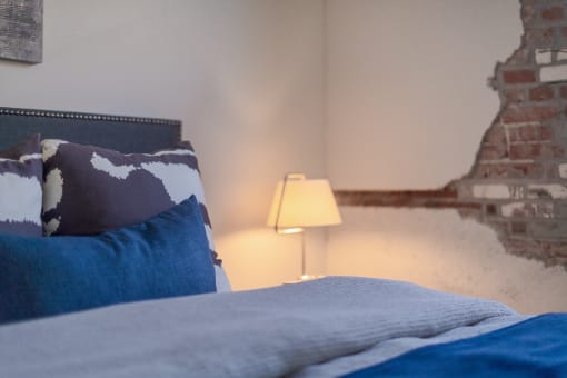 a bedroom with a bed and a lamp at The 22 Apartments, St. Louis