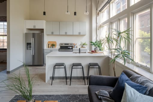 a kitchen with a large window and a white island with a white countertop at The 22 Apartments, Missouri, 63103