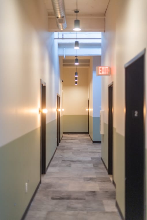 a long corridor with black doors and white walls at The 22 Apartments, St. Louis, MO
