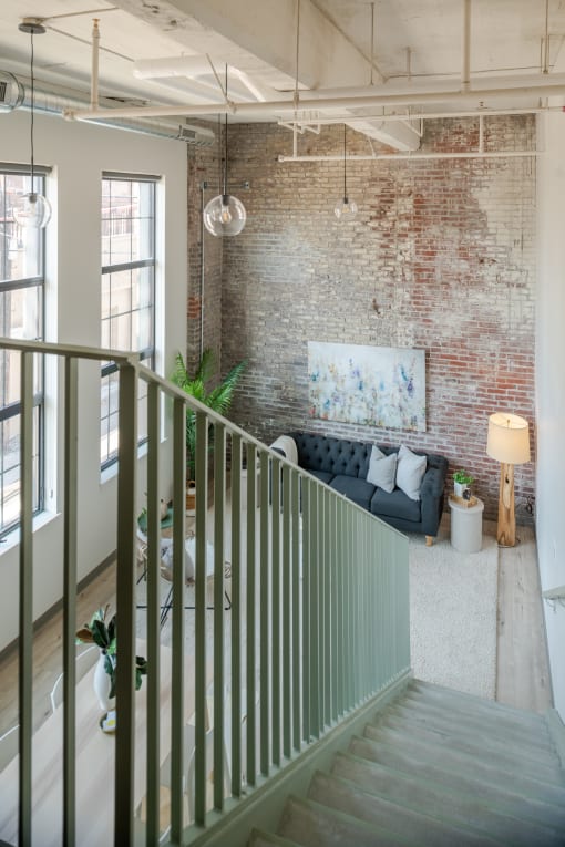 a living room with a brick wall and a couch in front of it at The 22 Apartments, Missouri