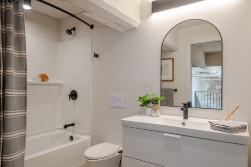 a bathroom with a white sink and toilet next to a white bathtub at The 22 Apartments, Missouri