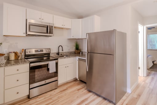 a kitchen with stainless steel appliances and white cabinets