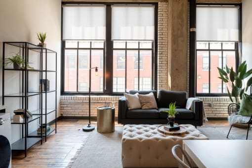 a living area with a couch coffee table and large windows at The Draper, Missouri