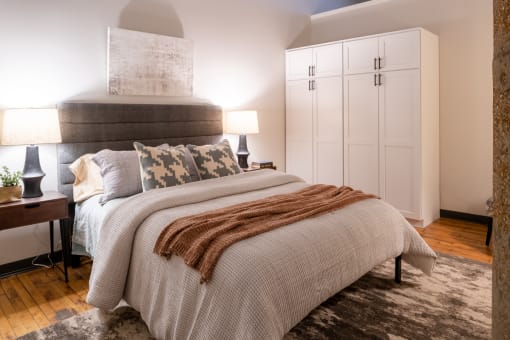a bedroom with a large bed and white cabinets at The Draper, Missouri