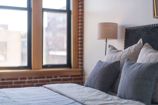 a bedroom with a bed and two windows