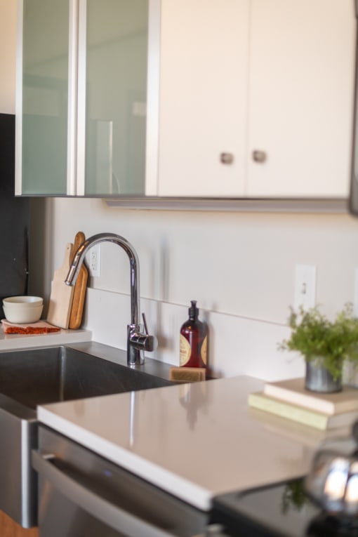a kitchen with white cabinets and a black sink