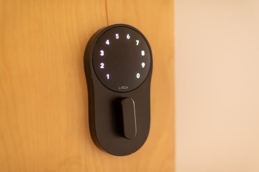 a black remote control with white buttons on a wooden door