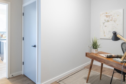 a home office with a wooden desk and a blue door