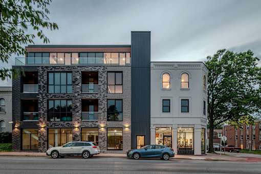 the exterior of a building with cars parked in front of it
