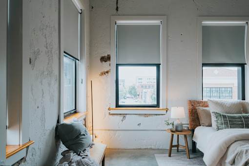A room with a bed, a window, and a lamp.