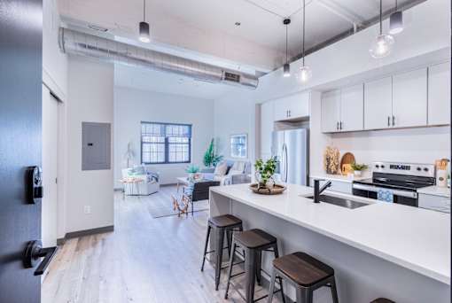A modern kitchen with white cabinets and a black refrigerator.