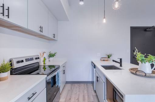 A modern kitchen with white cabinets and a black oven.