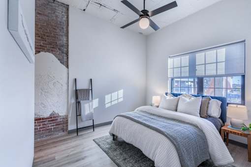 A bedroom with a large bed and a ceiling fan.