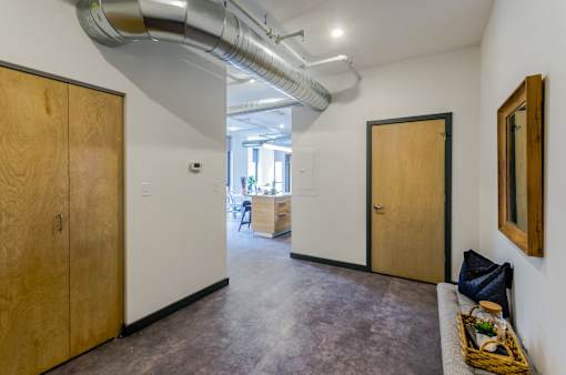 A room with a wooden door and a basket of fruit on the floor.