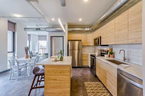 A modern kitchen with a wooden island and stainless steel appliances.