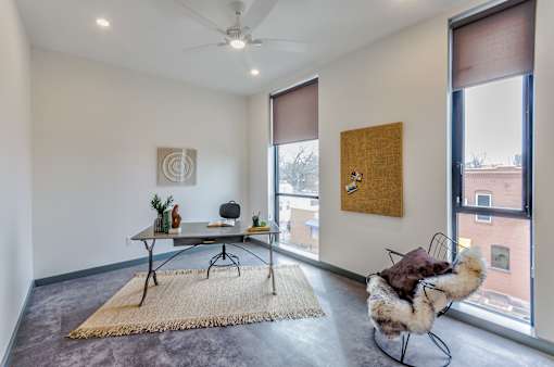 A room with a table, chairs, and a rug.