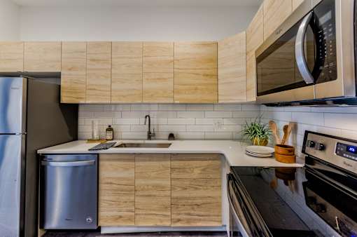 A modern kitchen with wooden cabinets and stainless steel appliances.