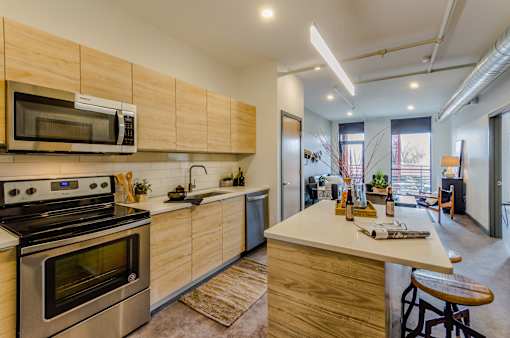 A modern kitchen with wooden cabinets and stainless steel appliances.