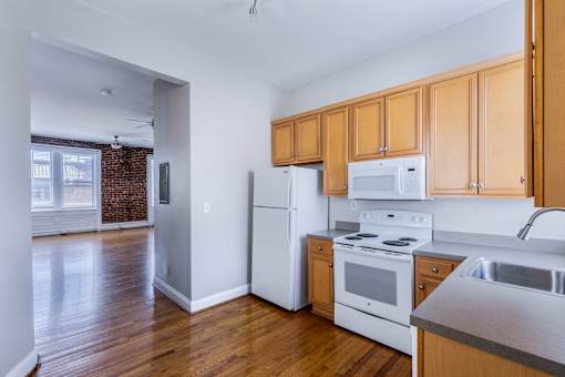 A kitchen with white appliances and wooden cabinets.