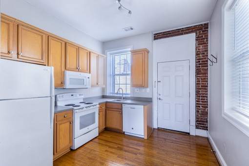 A kitchen with wooden cabinets and white appliances.