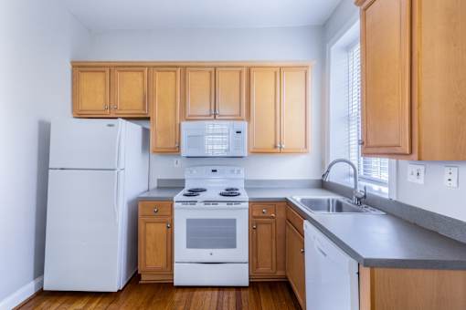 A kitchen with wooden cabinets and white appliances.