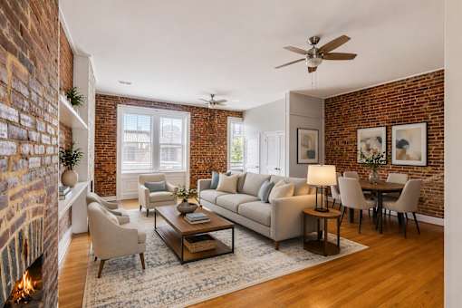 A living room with a brick wall and a fireplace.