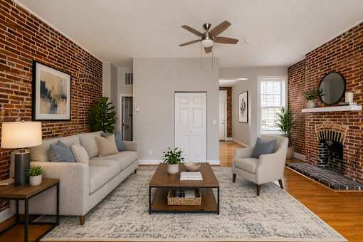 A living room with a brick wall and a fireplace.