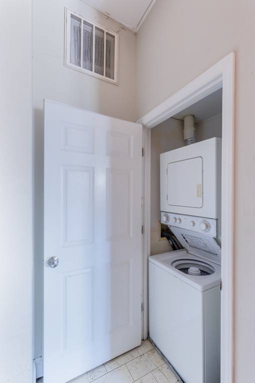 A white door is open to a small laundry room with a washer and dryer.