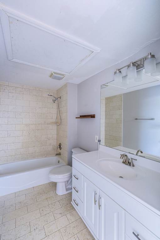 A white bathroom with a tub, toilet, and sink.