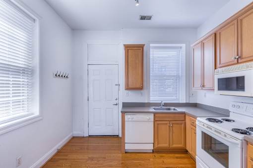 A kitchen with white appliances and wooden cabinets.