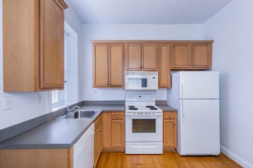 A kitchen with wooden cabinets and white appliances.